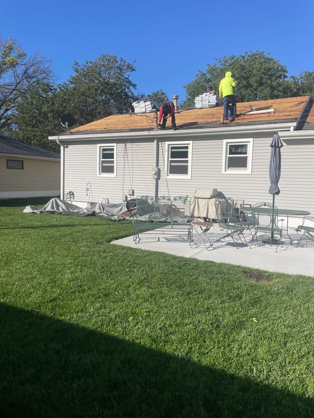 Mid-repair: crew tearing off old shingles