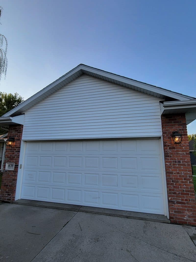 Completed white vinyl siding garage